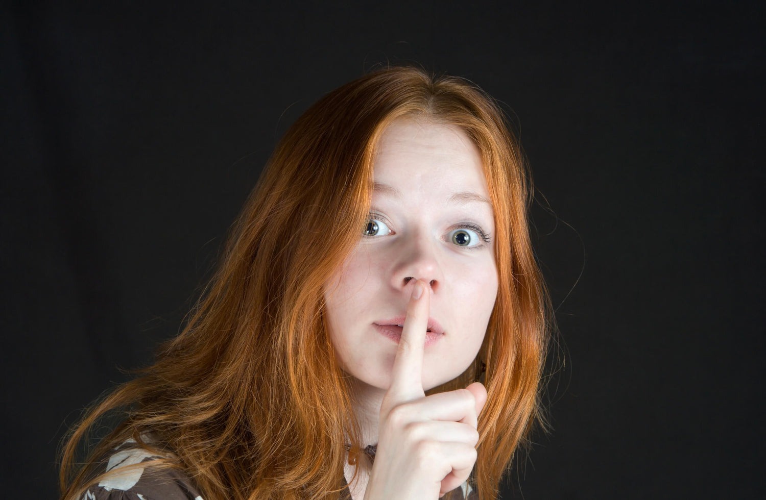 Woman being quiet with finger over her mouth